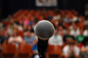 close up of microphone with an audience in the background